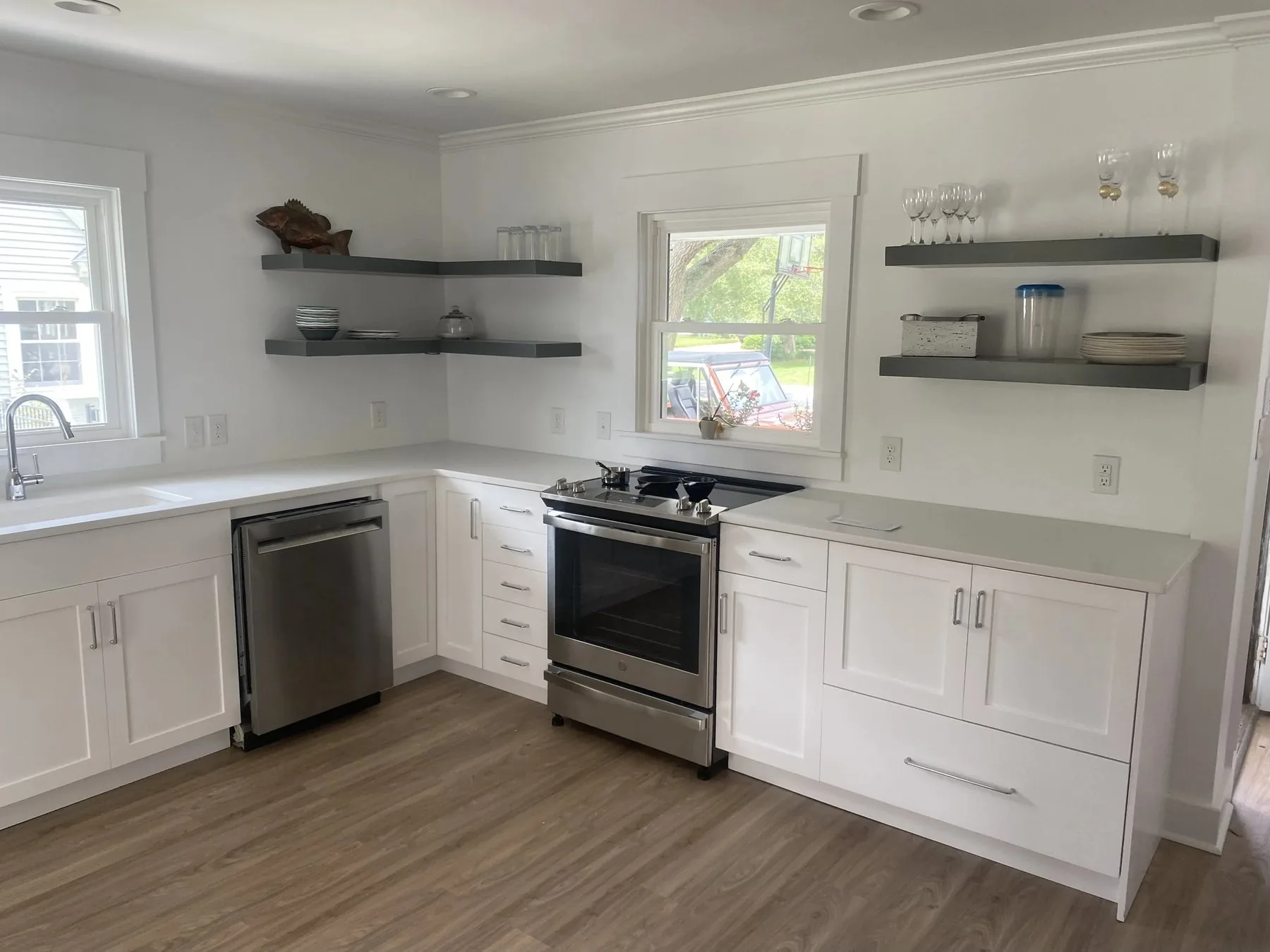 Custom white kitchen cabinetry with dark floating shelves