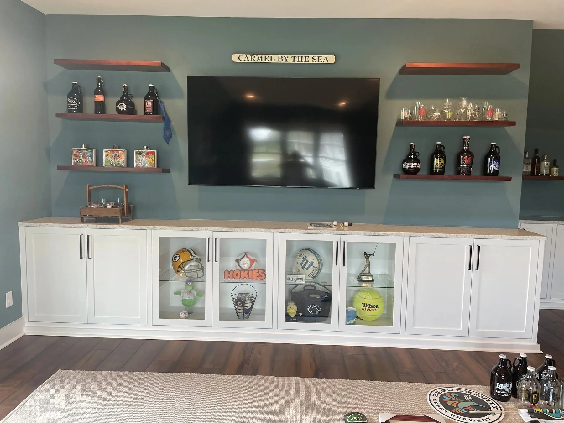 Custom built-in media wall with glass front cabinets and floating shelves
