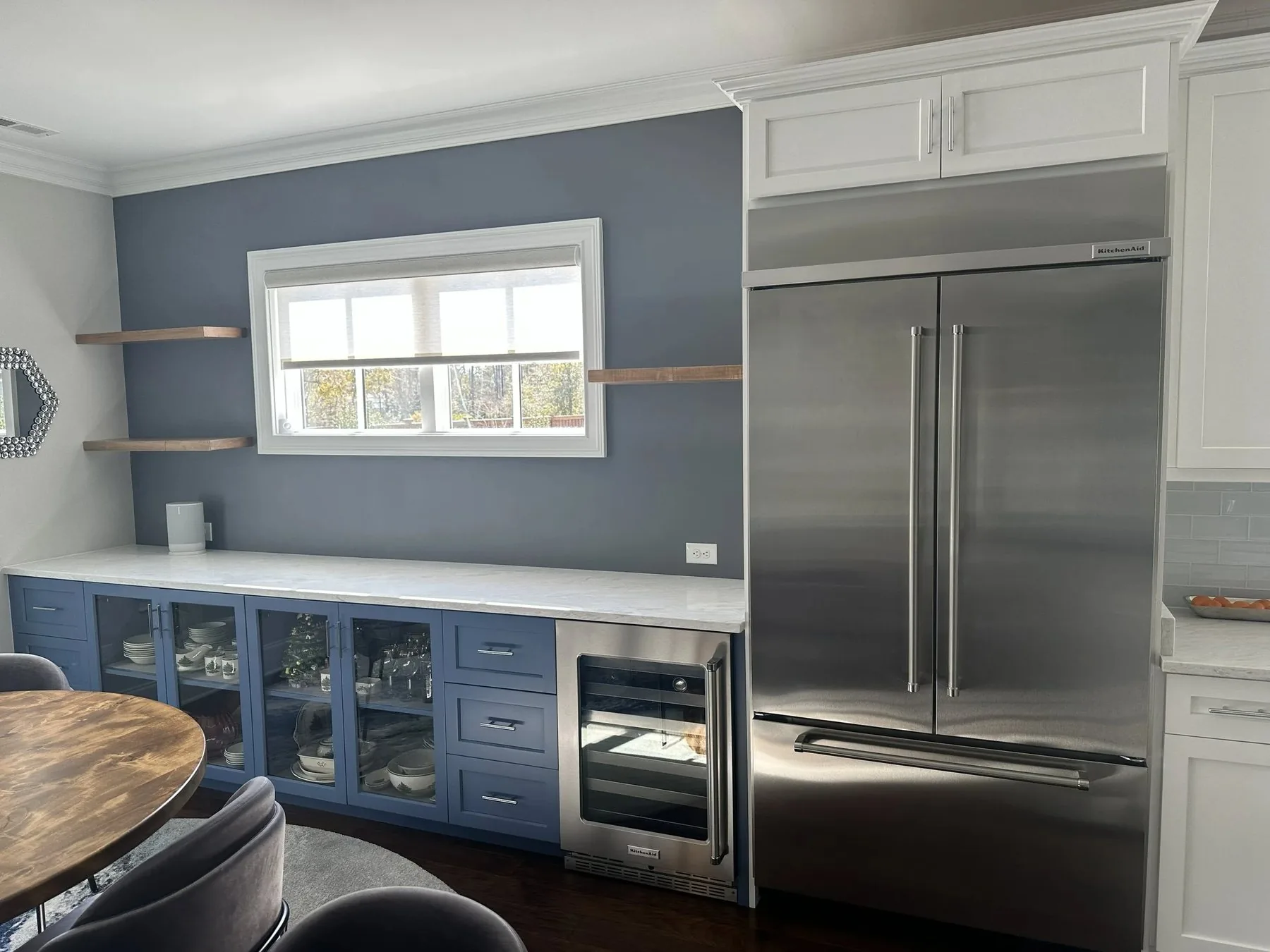 Custom kitchen cabinetry with a blue island and open shelving